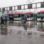 Busstation Nijmegen met reizigers in de regen