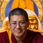 Een close up van een ernstig kijkende Demo Rimpoche.
