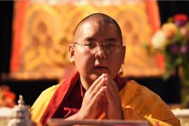 Een close up van Kyabje Yongdzin Ling Rinpoche met gevouwen handen.